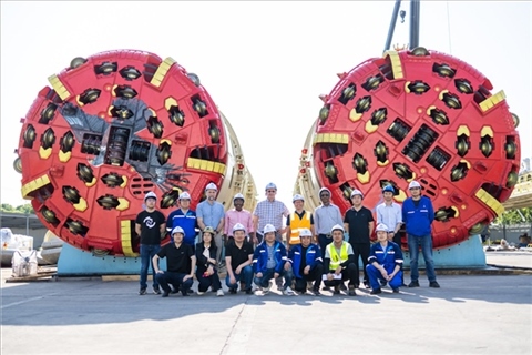 中外員工在盾構(gòu)機(jī)前合影。中國電建供圖