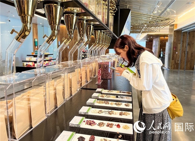 4. 代表團(tuán)團(tuán)員對新中式茶飲的食材充滿興趣。（人民網(wǎng)記者陳思 攝）