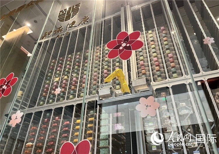 6. 機(jī)械臂正在取貨。（人民網(wǎng)記者陳思 攝）