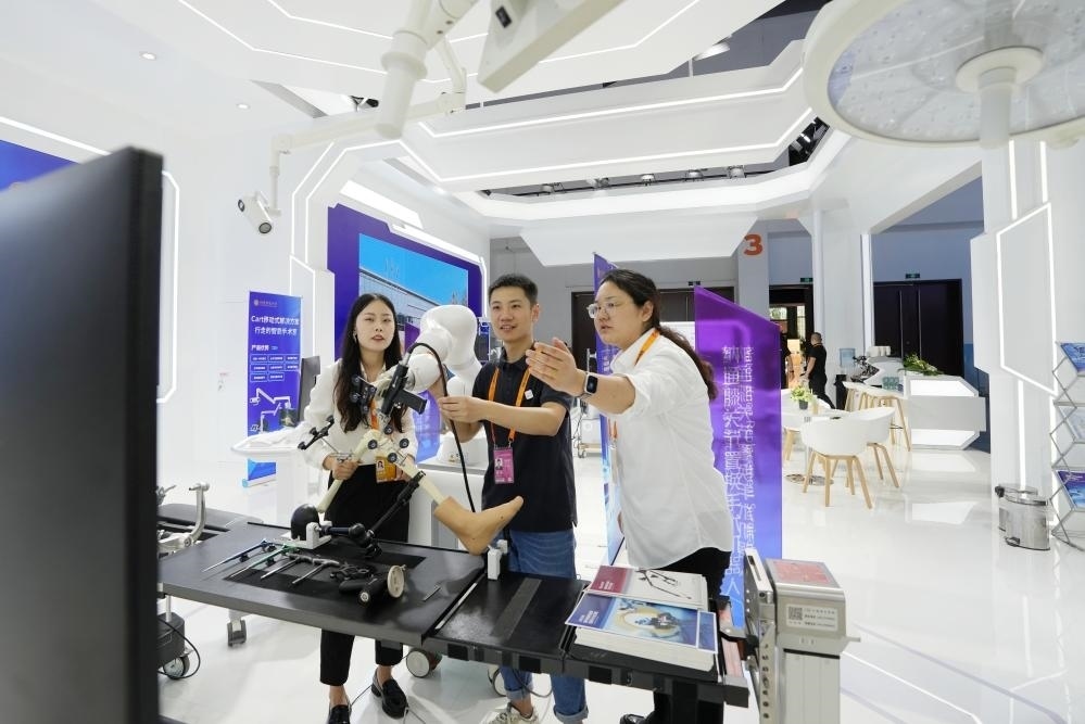9月11日，一位媒體記者（中）在2024年服貿(mào)會國家會議中心會場體驗北京納通科技集團(tuán)有限公司的膝關(guān)節(jié)置換手術(shù)機器人。新華社記者鞠煥宗 攝