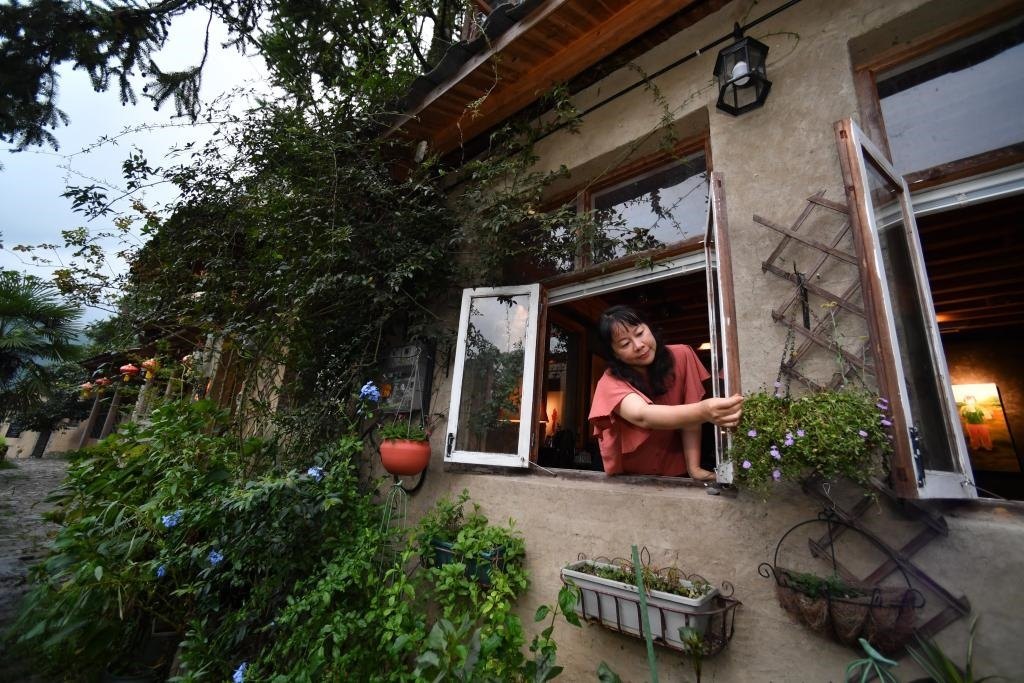 8月29日，在福建省屏南縣熙嶺鄉(xiāng)，龍?zhí)洞濉靶麓迕瘛泵泛暝诖蚶碜约航?jīng)營的民宿外墻裝飾花盆。新華社記者姜克紅 攝