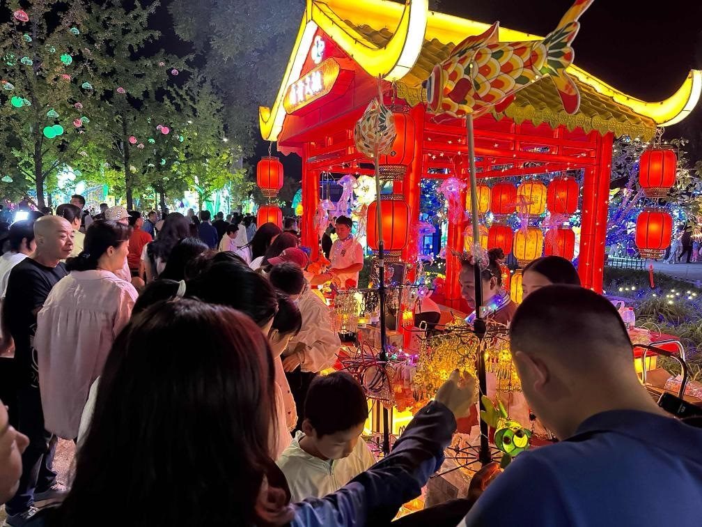 市民游客在2024年北京中秋國(guó)慶彩燈游園會(huì)上選購(gòu)特色文創(chuàng)商品。新華社記者楊淑君 攝