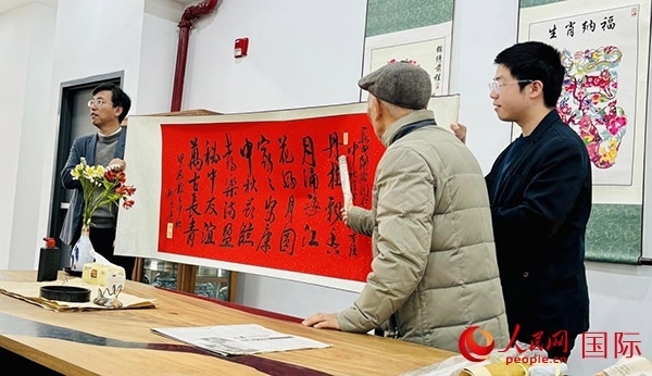 旅秘書法家向現(xiàn)場觀眾展示書法作品。人民網(wǎng)記者 宋亦然攝