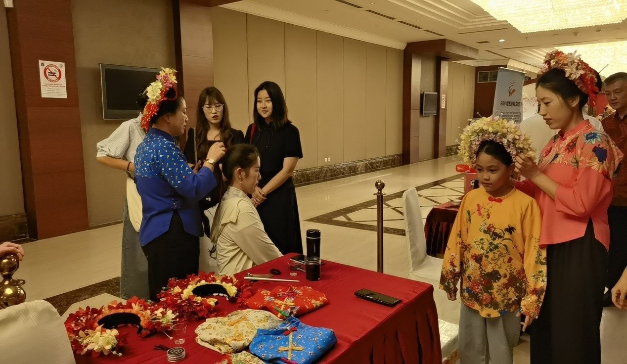 阿拉扎大學(xué)孔子學(xué)院志愿者老師向傳承人學(xué)習簪花圍。阿拉扎大學(xué)孔子學(xué)院供圖