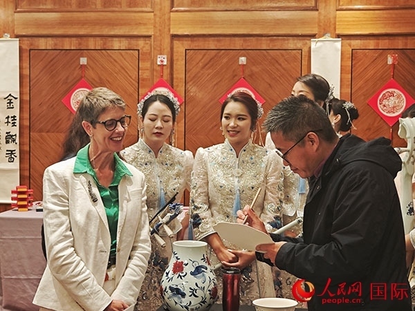 現(xiàn)場的非遺傳承人為英國觀眾展示畫技。人民網(wǎng)記者 邢雪攝