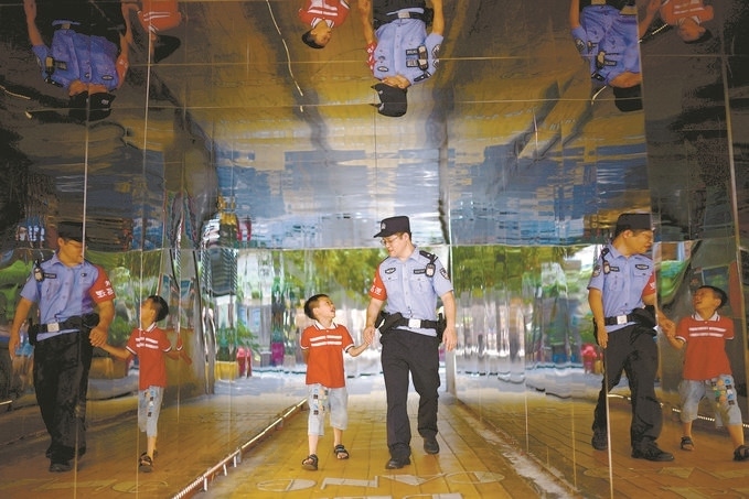 ?7月16日，重慶市公安局江北區(qū)分局一名民警在巡邏途中遇到一個(gè)獨(dú)自玩耍的小男孩，民警將其送回家。王洪平攝