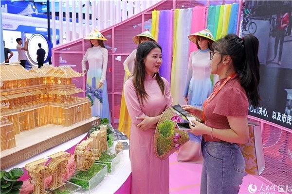 參觀者在東博會(huì)越南展區(qū)同工作人員咨詢交談。人民網(wǎng)記者 趙益普攝