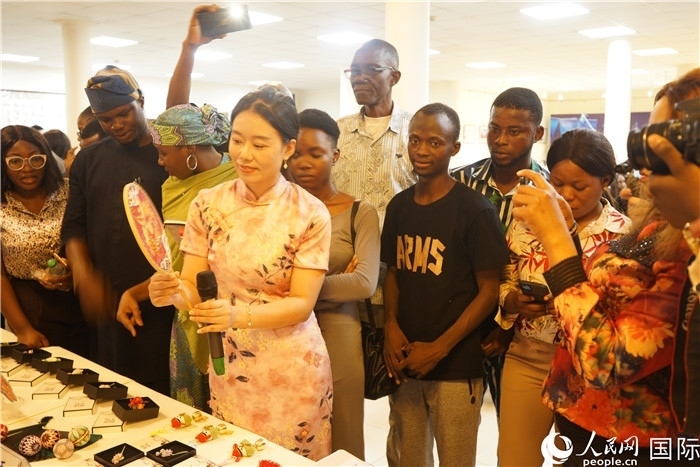 向尼日利亞觀眾介紹中國(guó)刺繡。人民網(wǎng)記者 姜宣攝