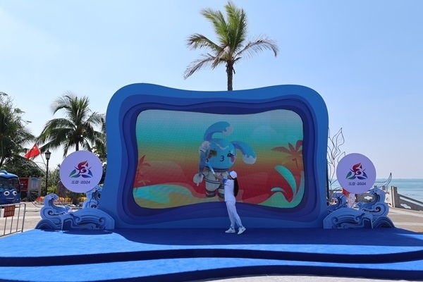 第12棒火炬手“點(diǎn)燃”現(xiàn)場大屏幕上運(yùn)動(dòng)會(huì)吉祥物“吉貝”手中的火炬。主辦方供圖