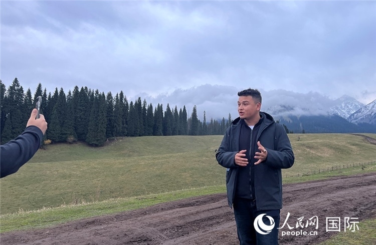 在庫爾德寧，吾買爾江被雪山美景震撼，即興錄制了短視頻作品。人民網記者曾書柔攝