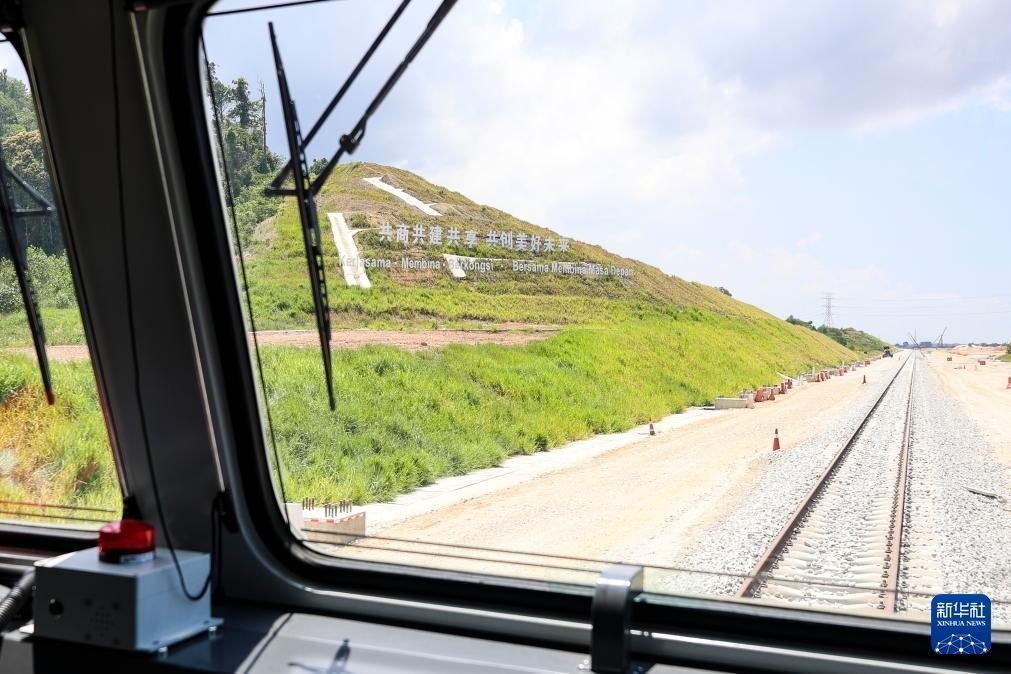 5月6日，在馬來西亞彭亨州馬東鐵項(xiàng)目沿途的山坡上，兩行中文和馬來文大字“共商共建共享，共創(chuàng)美好未來”映入眼簾。新華社記者 程一恒 攝