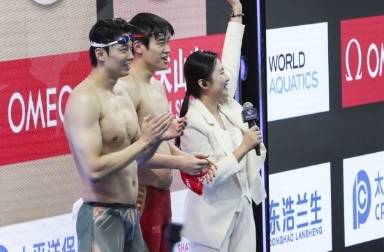 10月18日，汪順（左）和潘展樂在男子100米混合泳決賽后。新華社記者 方喆 攝