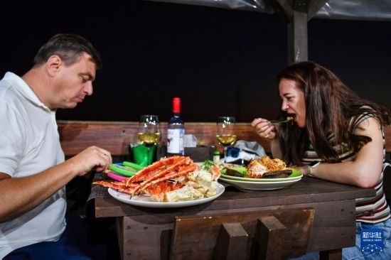 9月2日，食客們在俄羅斯符拉迪沃斯托克的一家餐館品嘗帝王蟹。新華社記者 曹陽 攝