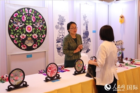 青海非遺文化傳承人向嘉賓介紹展品。人民網(wǎng)實習(xí)生姚欣可攝