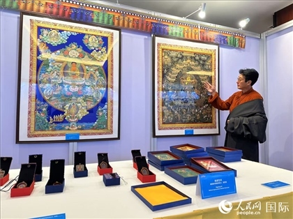 熱貢藝術(shù)國家級代表性傳承人夏吾角向嘉賓介紹作品。人民網(wǎng)記者 簡承淵攝