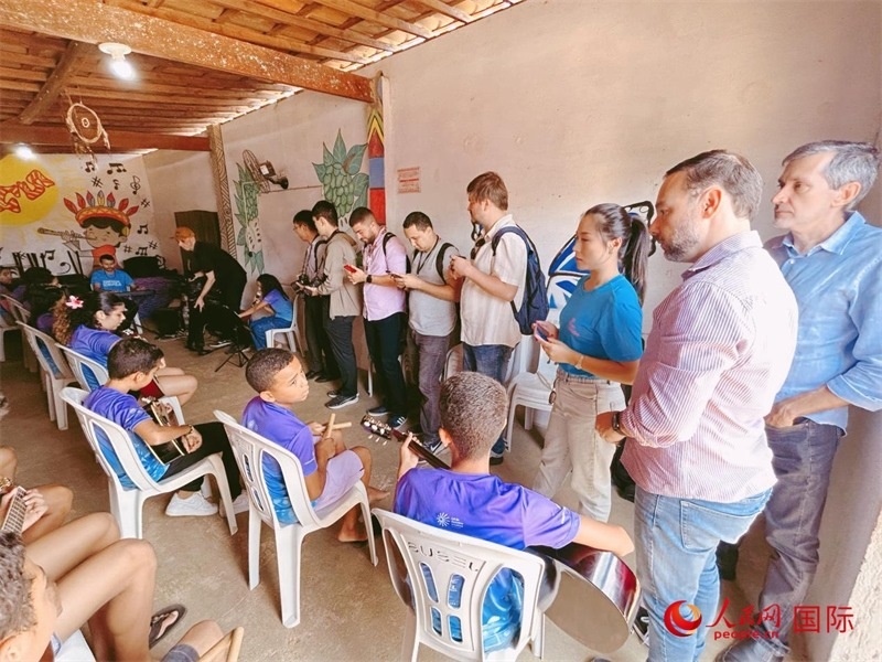  受益于中國企業(yè)的“青少年成長”項(xiàng)目，700多名當(dāng)?shù)厍嗌倌甑囊魳泛妥闱驂粝氩迳狭顺岚?。圖為聯(lián)合采訪團(tuán)正在采訪參加音樂培訓(xùn)的孩子們。 人民網(wǎng)記者 陳一鳴攝