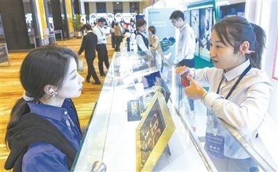 在北京麗澤商務(wù)區(qū)，工作人員（右一）介紹數(shù)字人民幣SIM卡硬錢包。新京報記者 陶冉攝