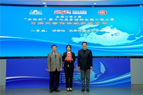 中國翻譯協(xié)會副會長中國外文局中東歐與中南亞傳播中心（人民畫報(bào)社）主任姜永鋼（右一）、原中國教育工會全國委員會巡視員白立文（左一）為獲得日語交傳組一等獎的北京外國語大學(xué)廖君怡頒獎（主辦方提供）