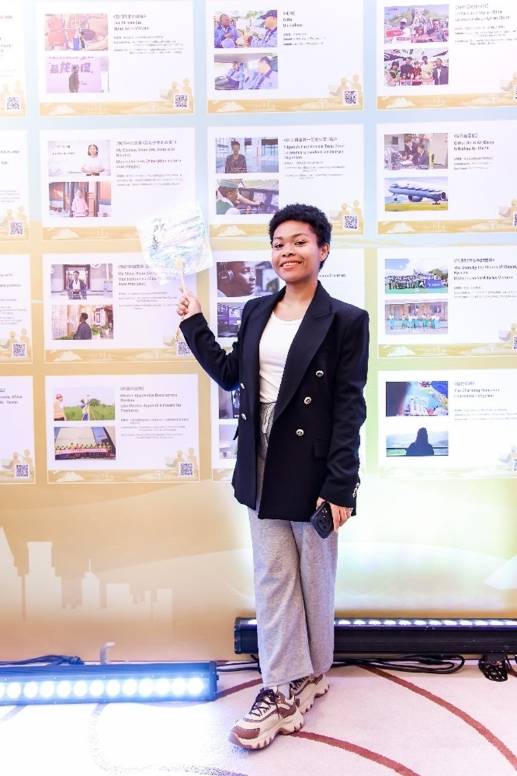 愈靈兒和她的作品合影。主辦方供圖