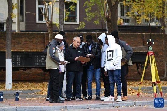 在天津鐵道職業(yè)技術學院，老師指導幾內(nèi)亞學員使用測距儀器（11月11日攝）。新華社記者 李然 攝