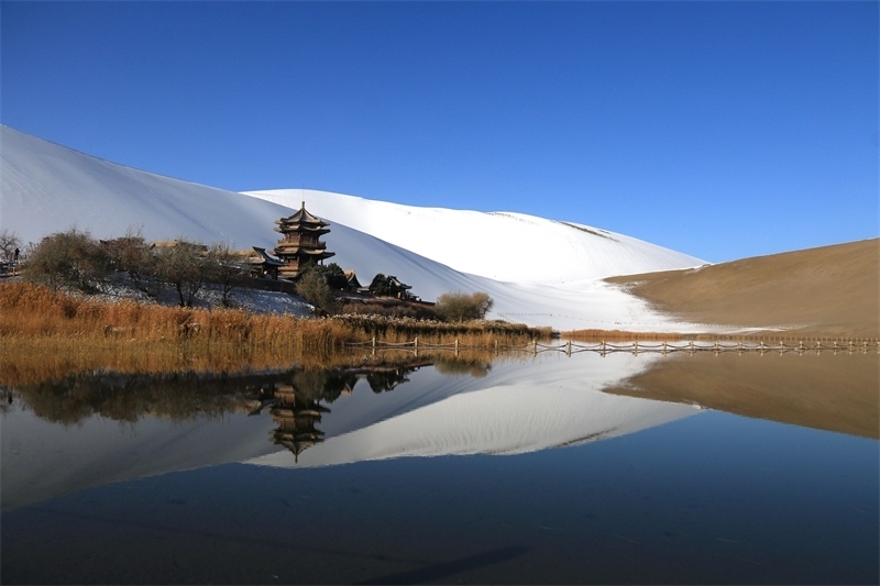 鳴沙山月牙泉景區(qū)雪景。敦煌市委宣傳部供圖，張曉亮攝