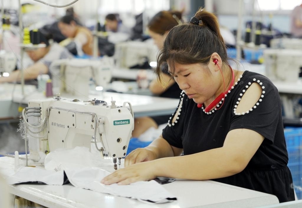 5月20日，村民在李寨村服裝加工廠內(nèi)忙碌。河南省周口市沈丘縣馮營(yíng)鎮(zhèn)李寨村地處豫東平原。近年來(lái)，乘著脫貧攻堅(jiān)與鄉(xiāng)村振興政策的東風(fēng)，李寨村積極探索產(chǎn)業(yè)發(fā)展模式，通過(guò)“龍頭企業(yè)+村集體經(jīng)濟(jì)+農(nóng)戶(hù)”的方式，逐漸發(fā)展形成肉牛養(yǎng)殖、設(shè)施農(nóng)業(yè)、服裝加工、康養(yǎng)民宿等產(chǎn)業(yè)，以產(chǎn)業(yè)振興助力鄉(xiāng)村振興。新華社記者 李嘉南 攝