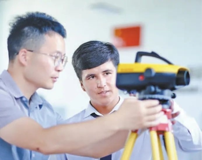 在塔吉克斯坦首都杜尚別的魯班工坊，來自天津城市建設(shè)管理職業(yè)技術(shù)學(xué)院的老師（左）為當(dāng)?shù)貙W(xué)生提供指導(dǎo)。新華社記者 鄭開君 攝