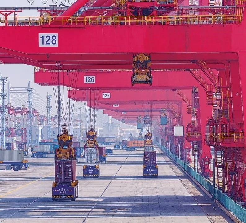 共建“一帶一路”國家在工作制度對接、技術(shù)標(biāo)準(zhǔn)協(xié)調(diào)、檢驗結(jié)果互認(rèn)等方面強(qiáng)化合作、統(tǒng)一標(biāo)準(zhǔn)，貿(mào)易自由化便利化水平不斷提升。上海洋山港海關(guān)對接共建國家進(jìn)出口貨物相關(guān)標(biāo)準(zhǔn)，推動通關(guān)一體化方式申報，提升通關(guān)效率。圖為無人駕駛的全自動導(dǎo)引車在洋山港穿梭往來，搬運集裝箱。王初 攝