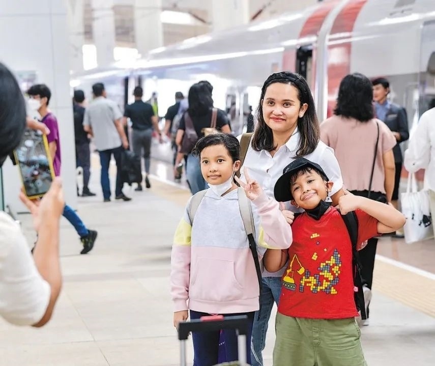 雅萬高鐵是我國在境外完成全過程勘察設(shè)計建設(shè)的首個高鐵項目，于去年10月17日正式開通運營，是中印尼共建“一帶一路”合作的典范。圖為乘客在和雅萬高鐵動車組合影留念。新華社記者 徐欽 攝