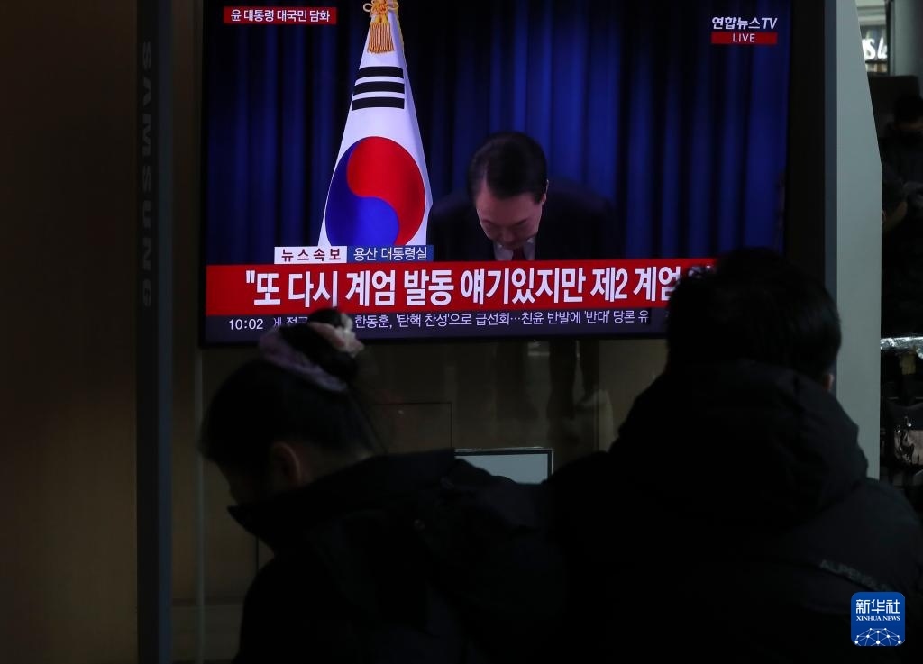 12月7日，在韓國首爾火車站，民眾觀看總統(tǒng)尹錫悅發(fā)表講話的電視畫面。新華社記者 姚琪琳 攝