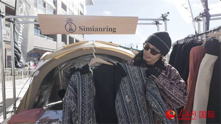 藤田周正在展示自己設(shè)計(jì)的滑雪服。人民網(wǎng)記者 袁蒙攝