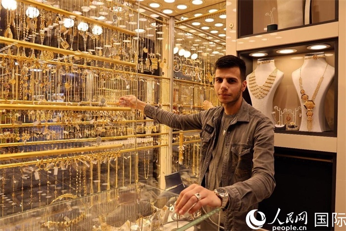 一名銷售員展示黃金飾品。人民網(wǎng) 伊納斯·易卜拉欣攝