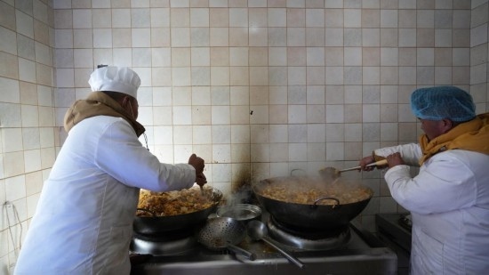 1月14日，服務(wù)隊的兩名廚師正在為村民們做午飯。新華社記者 邱星翔 攝