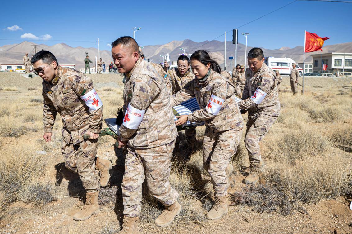 1月9日，日喀則定日縣長所鄉(xiāng)，西藏軍區(qū)總醫(yī)院醫(yī)療隊隊員將受傷村民用擔架從救護車準備抬上直升機，轉運至拉薩的西藏軍區(qū)總醫(yī)院救治。人民日報記者張武軍攝