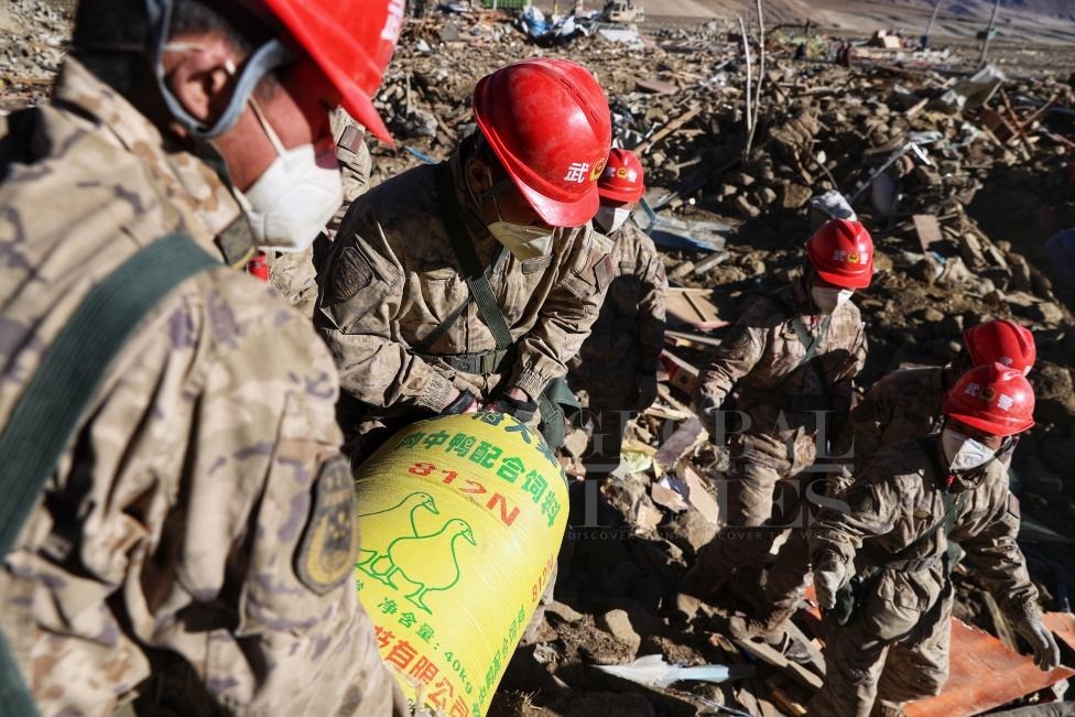 1月10日，定日縣長所鄉(xiāng)古榮村，武警官兵幫助受災群眾整理廢墟，搶救被掩埋的物資。環(huán)球時報記者崔萌攝