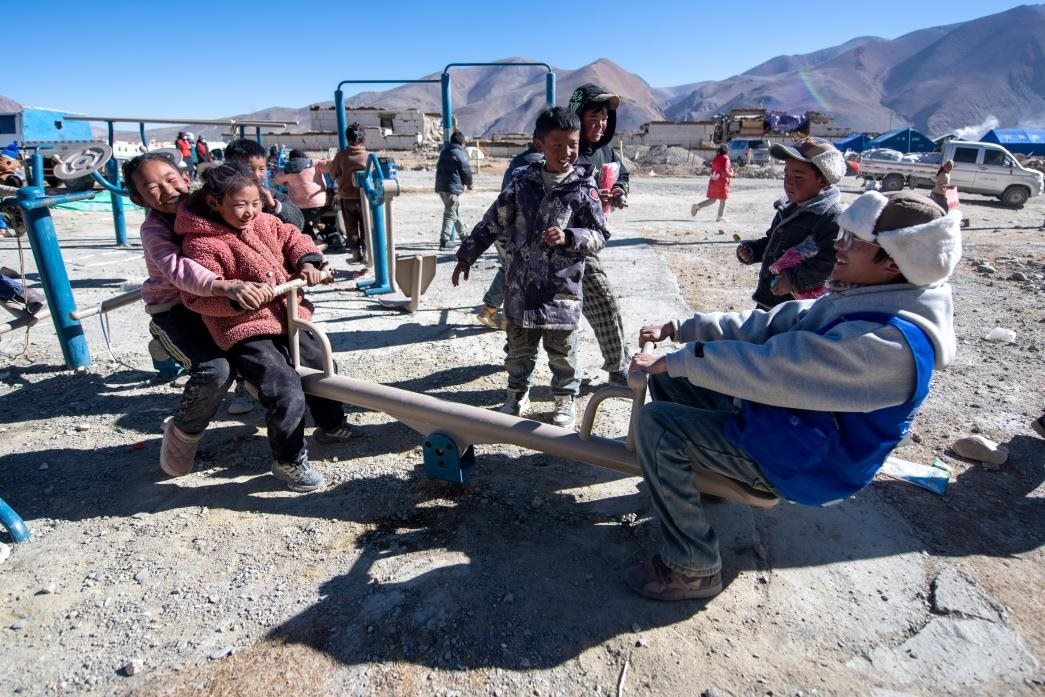 1月11日，在定日縣措果鄉(xiāng)塘仁村安置點，西藏星光社會工作服務中心志愿者和孩子們一起玩耍，進行災后心理疏導。人民網(wǎng)記者 翁奇羽攝