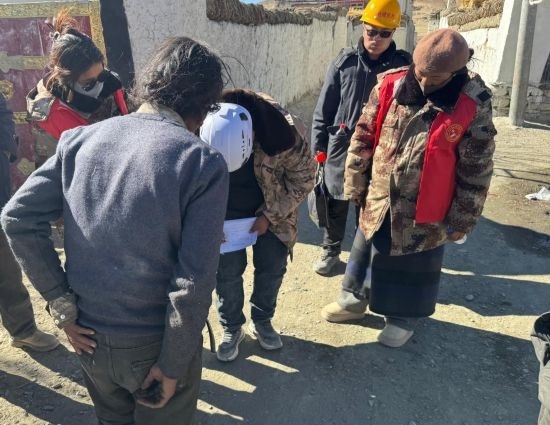 1月13日，次旺（右一）陪同工作組走訪村莊，評(píng)估房屋受損程度。新華社發(fā)