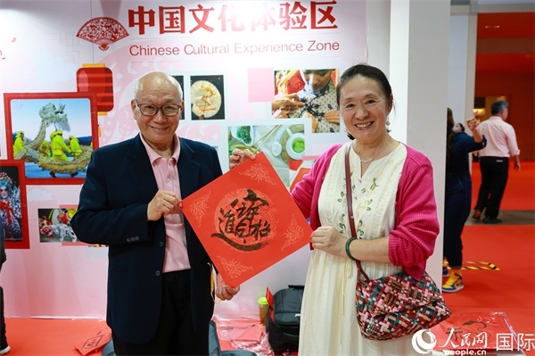 本地觀眾在中國文化體驗(yàn)區(qū)展示書法作品。人民網(wǎng)記者 白元琪攝