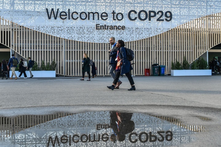 2024年11月15日，在阿塞拜疆首都巴庫(kù)，人們經(jīng)過(guò)聯(lián)合國(guó)氣候變化巴庫(kù)大會(huì)的會(huì)場(chǎng)。新華社記者 曹陽(yáng) 攝