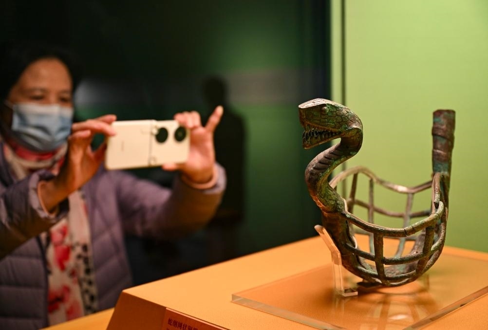1月14日，觀眾在上海博物館蛇年迎春展拍攝展品蛇綱網(wǎng)狀銅器。新華社發(fā)（陳浩明攝）