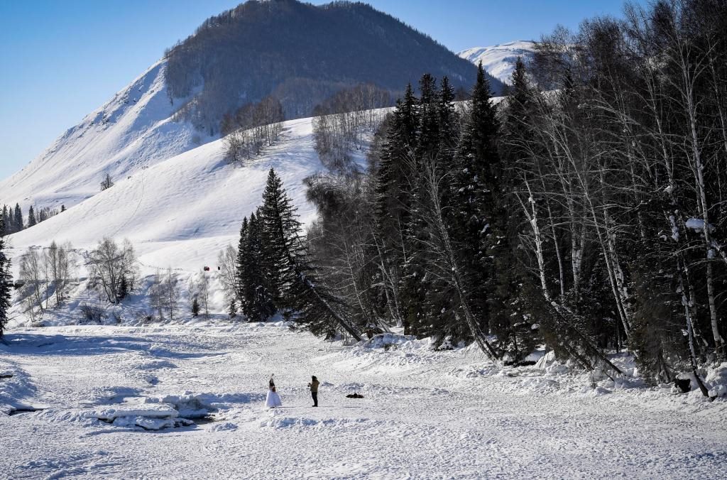 2024年2月5日，兩名游客在新疆阿勒泰地區(qū)布爾津縣禾木村拍照。新華社記者 馬鍇 攝
