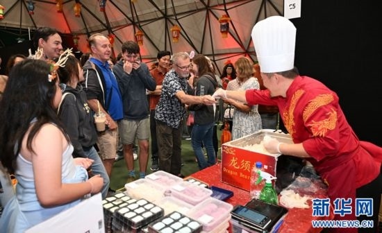 圖為游客在燈節(jié)現(xiàn)場(chǎng)購(gòu)買小吃。（圖片由奧克蘭中國(guó)文化中心提供）