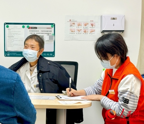 秦苑（中）接診患者。人民網(wǎng)記者 金慧慧攝