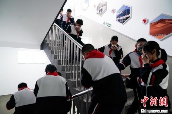  圖為學(xué)生們進(jìn)行應(yīng)急疏散演練。中新社記者 趙宇航 攝