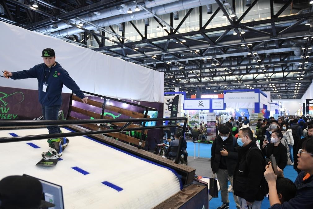 2023年2月11日，參觀者在展會上了解一款模擬滑雪設(shè)備。當(dāng)日，2023亞洲運動用品與時尚展在國家會議中心拉開帷幕。新華社記者 張晨霖 攝