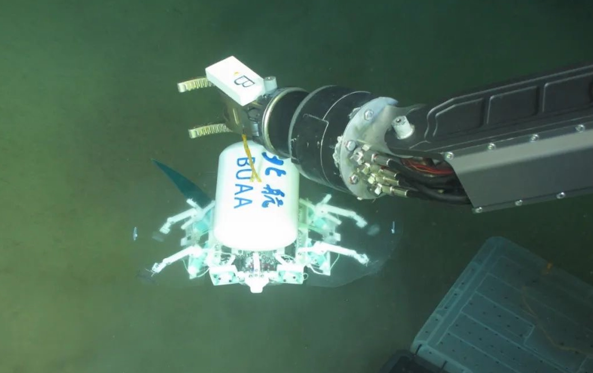 科研人員利用機(jī)械臂將北航深海小型機(jī)器人投于馬里亞納海溝。校方供圖