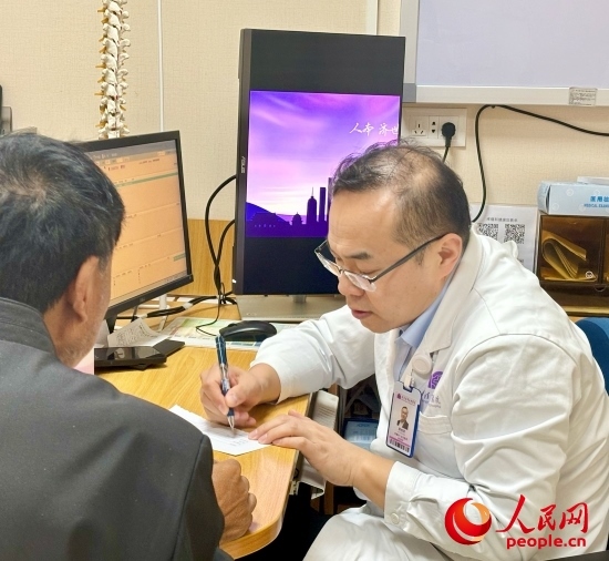 路桂軍接診時(shí)為患者寫下用藥提示。人民網(wǎng)記者 金慧慧攝