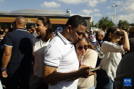  4月8日，人們聚集在多米尼加首都圣多明各的夜總會屋頂坍塌事故現(xiàn)場附近。新華社發(fā)