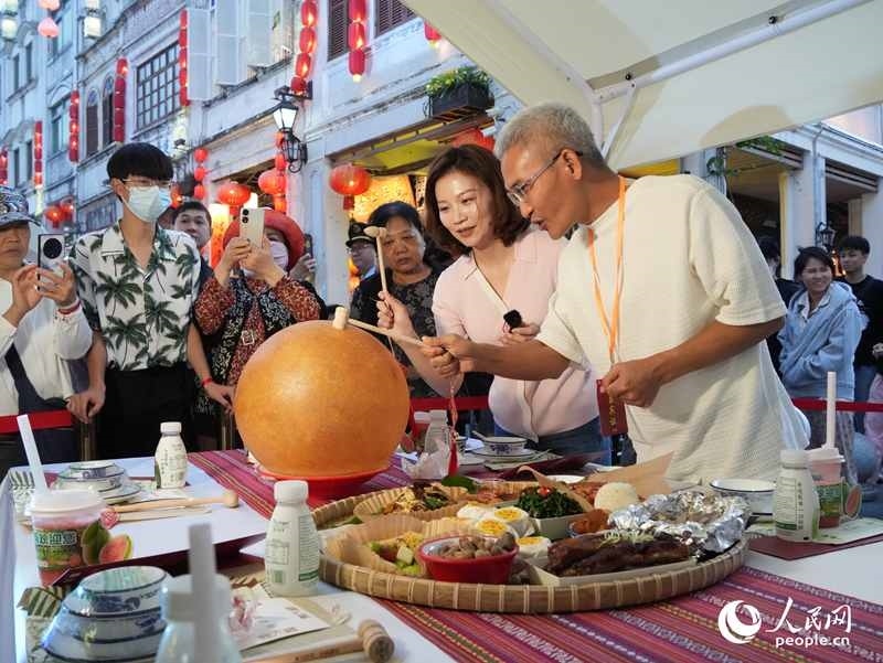 嘉賓品嘗海南傳統(tǒng)美食“煎堆”。人民網(wǎng)記者 張力洋攝