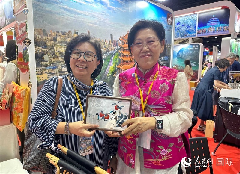 中國(guó)“大冶刺繡”傳承人劉小紅（右）參加泰國(guó)國(guó)際旅游展，向觀眾介紹中國(guó)非遺刺繡針法。人民網(wǎng)記者 簡(jiǎn)承淵攝